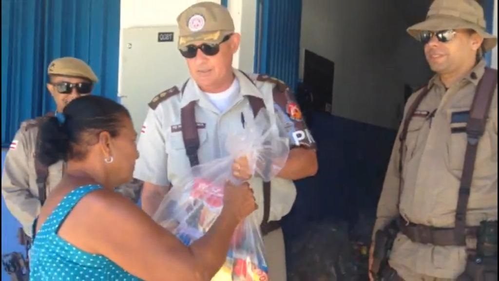 Tenente Coronel Normanha entrega cesta básica à moradora.